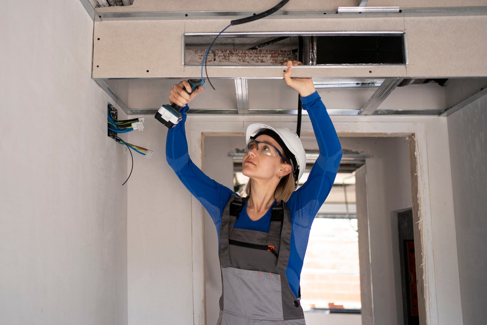 Woman working on ceiling installation.