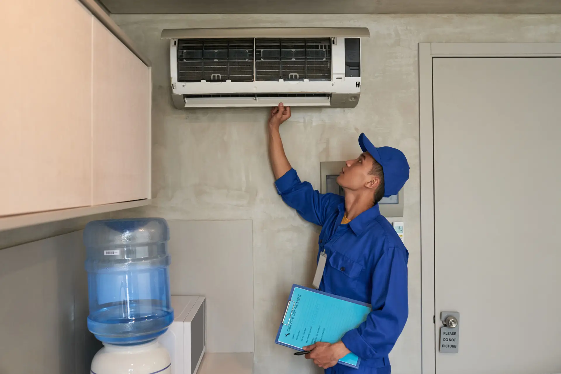 Technician cleaning and servicing ductless mini split unit in Dallas TX home