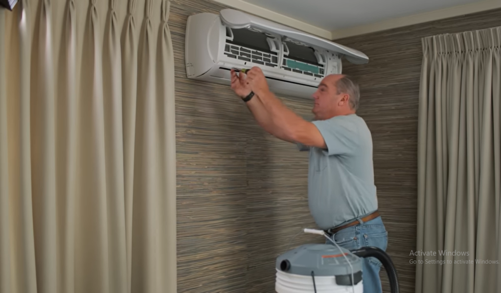 Mini split air conditioner indoor unit being cleaned during routine maintenance